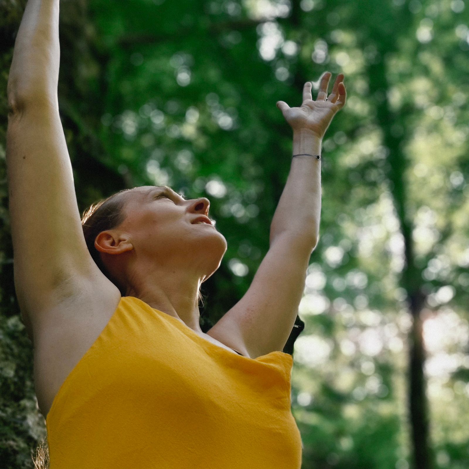 Eva-Maria (Ævama) in einem Wald mit beiden Händen nach oben gestreckt